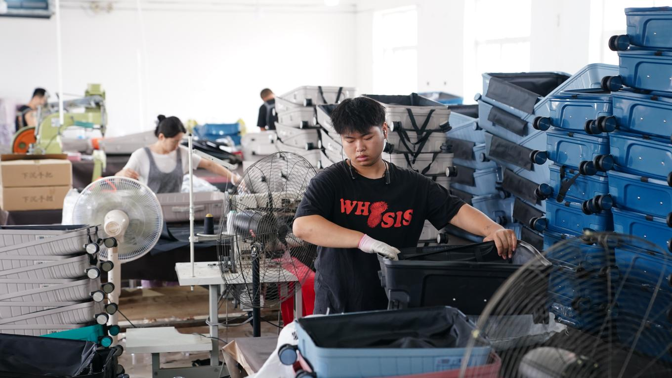 7月4日,，工人在白溝新城鵬杰皮具有限公司生產(chǎn)車間忙生產(chǎn)、趕訂單,。孫珞瑜攝